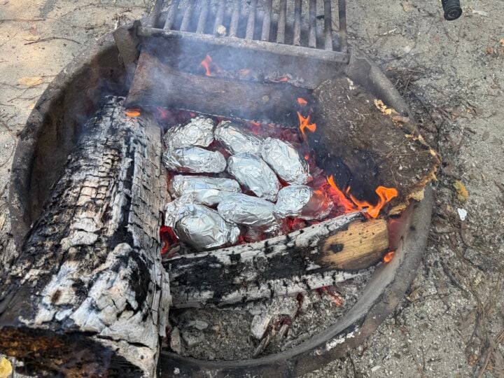 image of baked potatoes on embers wrapped in foil