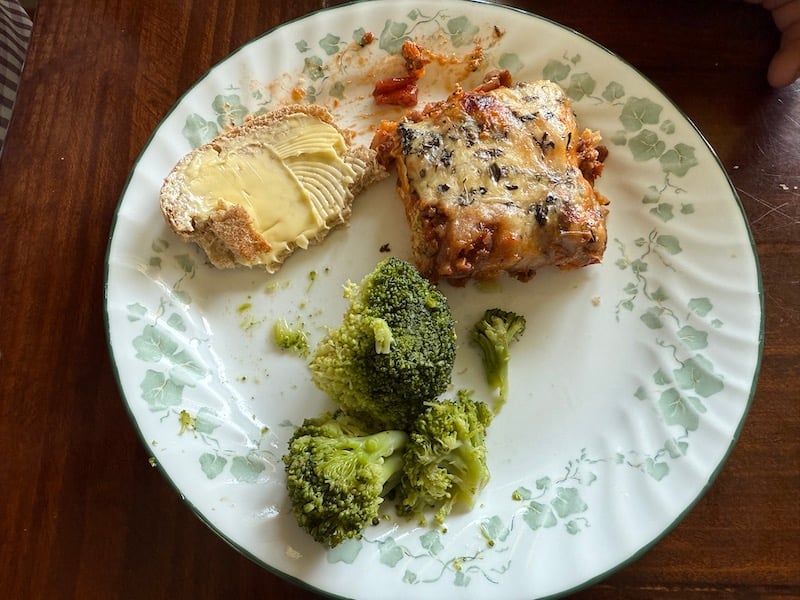 image of how to serve freezer lasagna (prepared freezer lasagna is baked and served with steamed broccoli and garlic bread on a dinner plate).