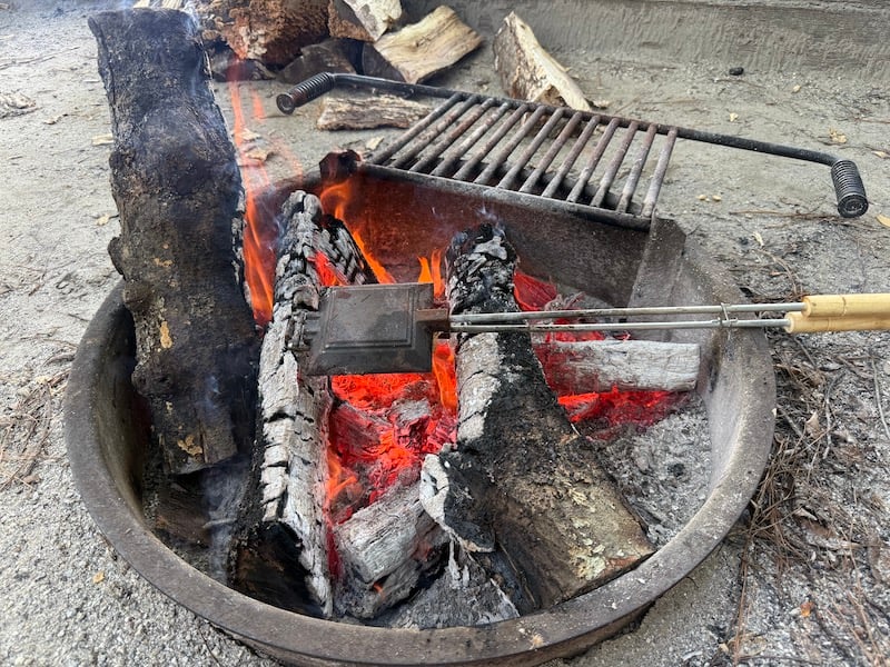 image of mountain pie maker over a fire to season
