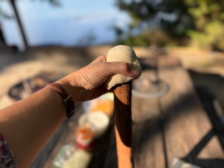 image of woof em sticks biscuit dough being pulled over a roasting stick