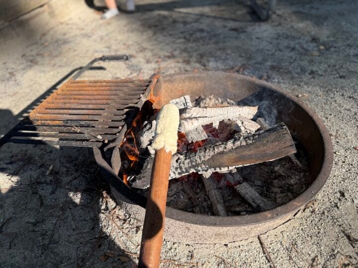 image of biscuit dough being roasted on a roasting stick by the fire