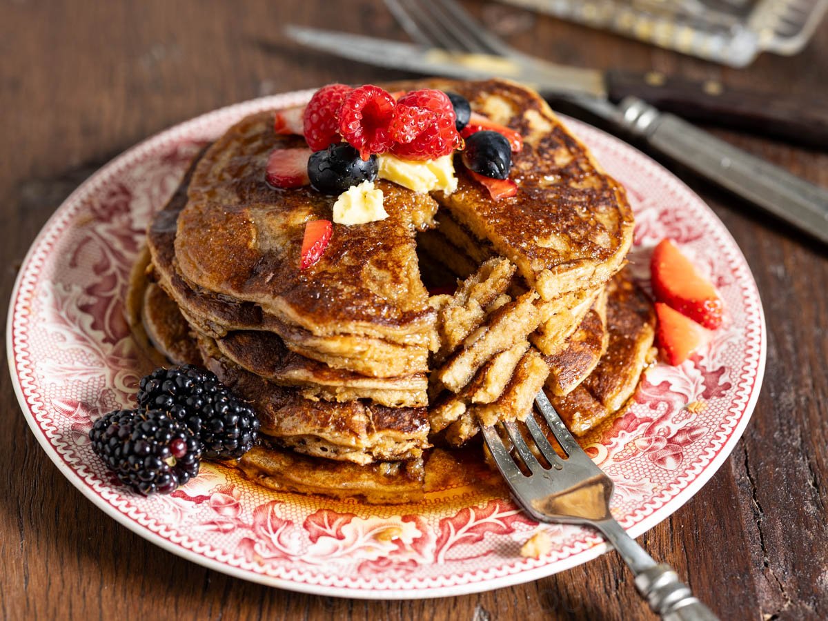 einkorn pancakes image of einkorn pancakes on a vintage red plate with a fork and berries