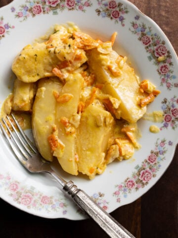 image of creamy potato wedges smothered in a heavy cream sauce with onions and carrots