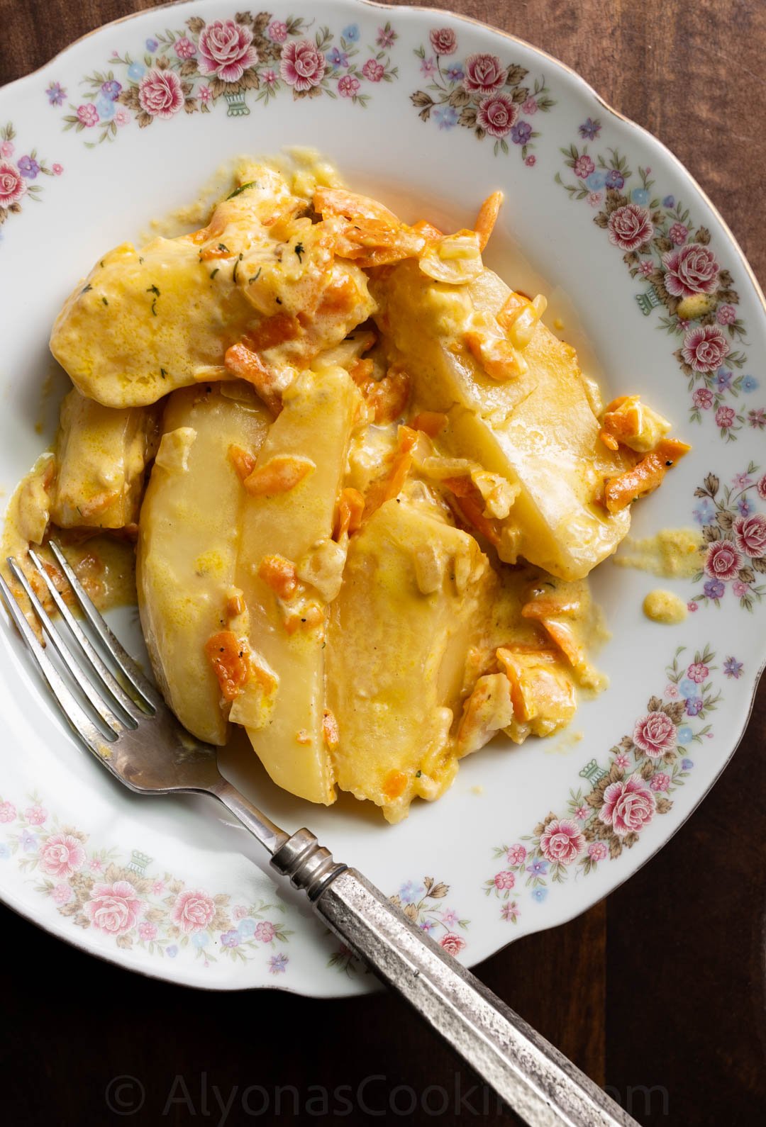 image of creamy potato wedges smothered in a heavy cream sauce with onions and carrots