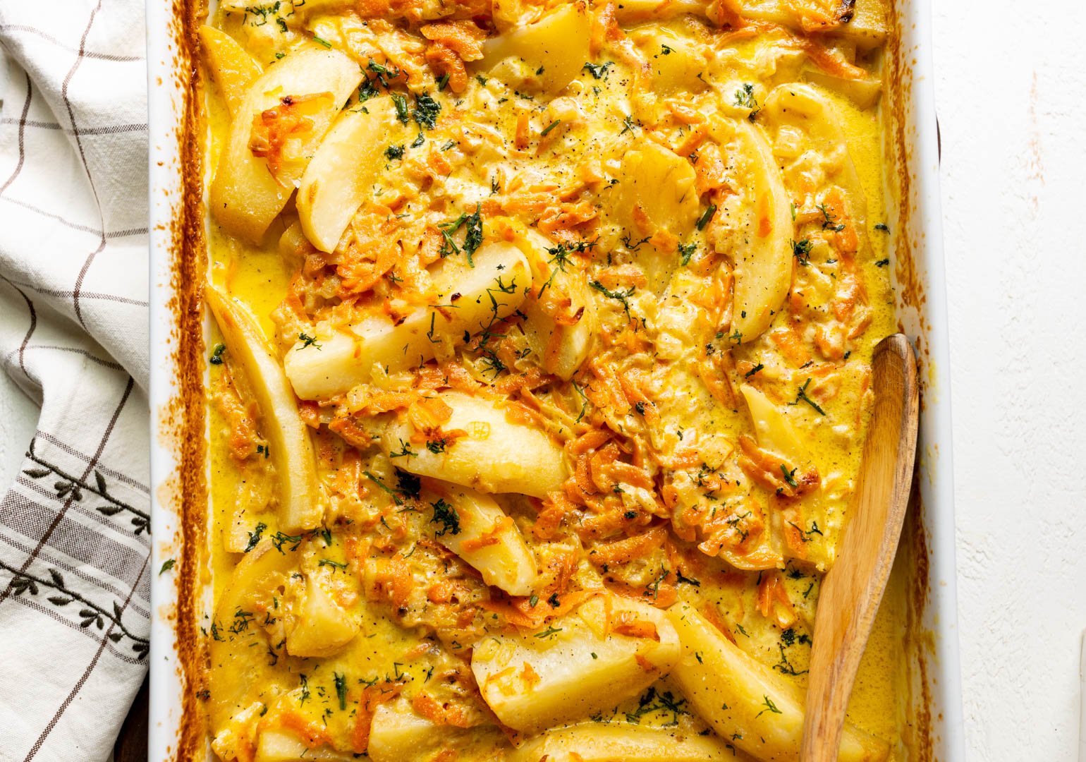 baked potato wedges in heavy cream, carrots, and onions garnished with dill