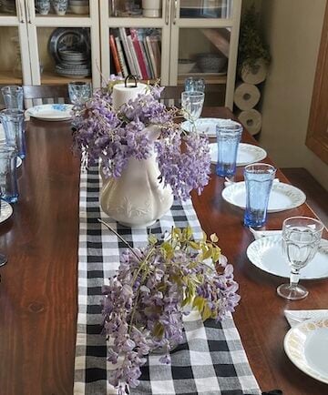 An image of a large farmhouse kitchen table set up for a meal as a homemakers featured image for the homemaking topics featured on Alyona's cooking