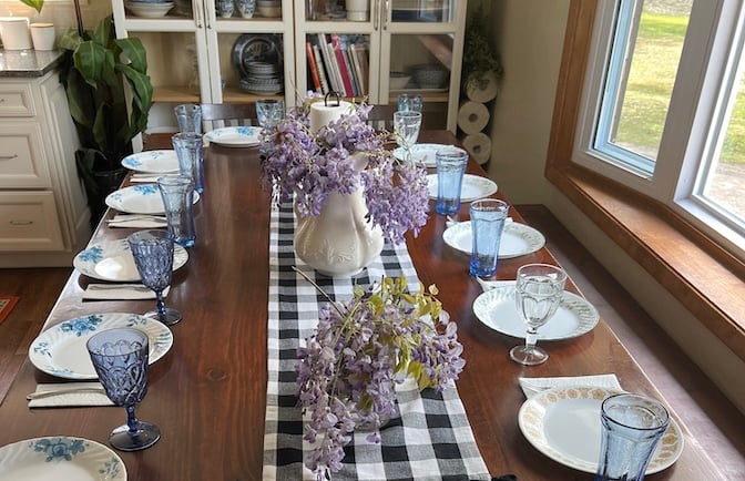 An image of a large farmhouse kitchen table set up for a meal as a homemakers featured image for the homemaking topics featured on Alyona's cooking