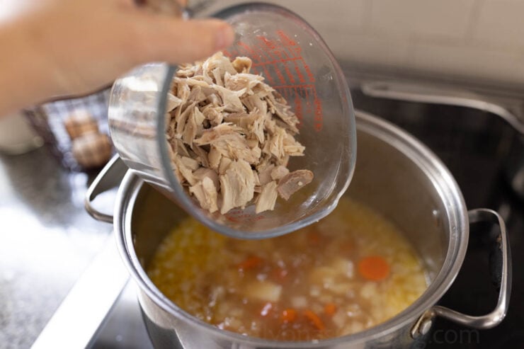 image of chopped chicken added to a pot of chicken chowder soup