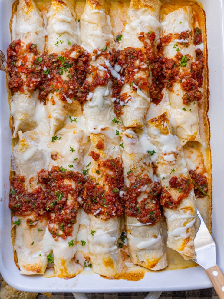 image of Instant pot chicken enchiladas with white melted cheese sauce and homemade salsa