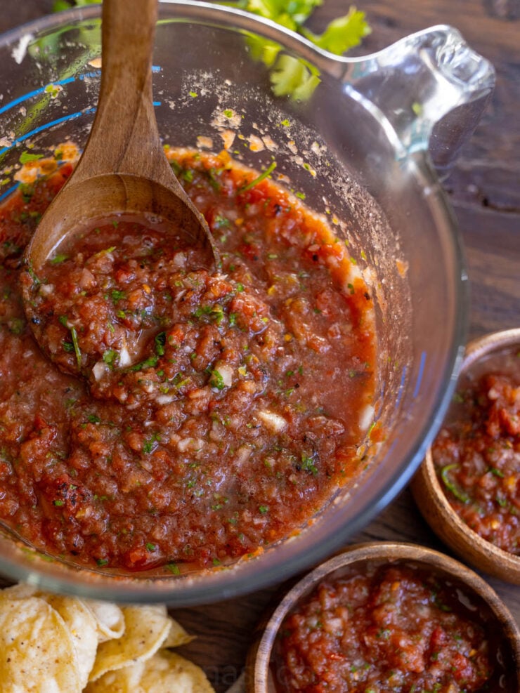 image of homemade salsa blended in a large glass measuring cup with a ladle spoon