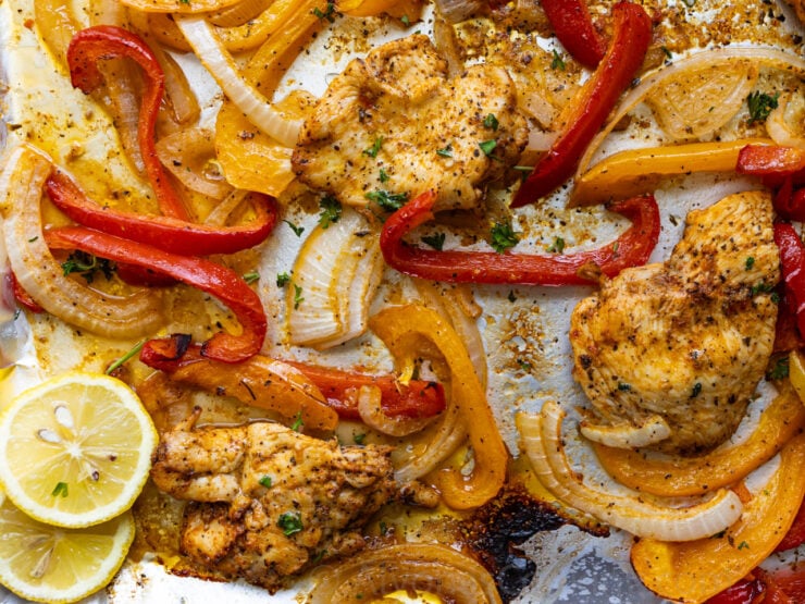 image of sheet pan Italian chicken and roasted bell peppers and onions garnished with lemon slices and fresh parsley 