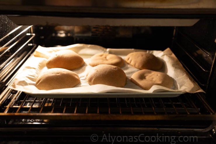 image of homemade whole grain pitas, puffed up in the oven