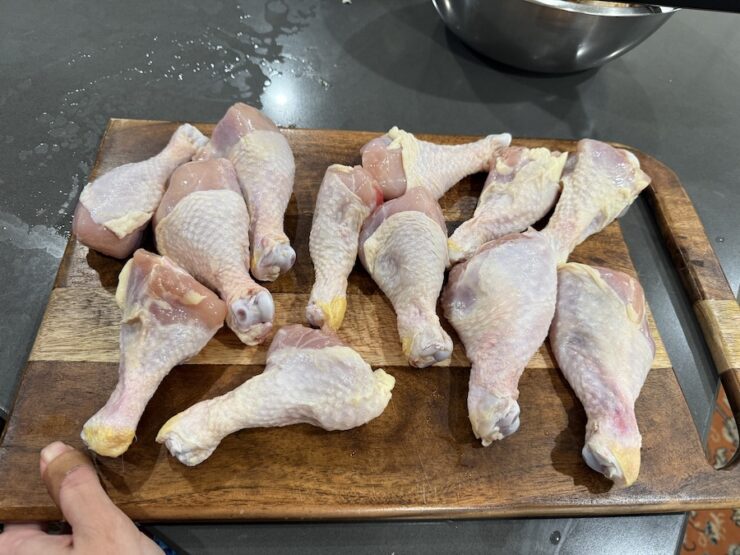 image of chicken drumsticks on a cutting board washed and clean (any feathers picked off).