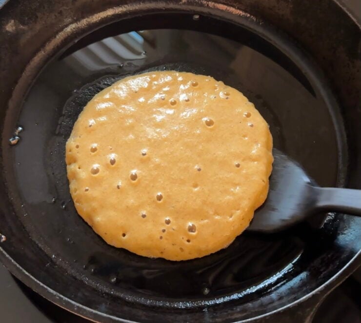 Image of Kamut pancake batter with holes on top ready to be flipped