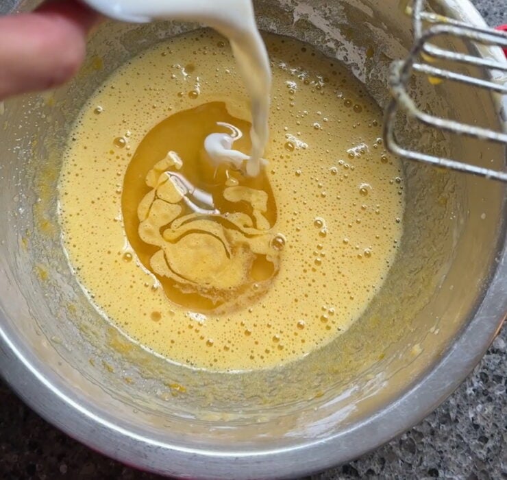 image of banana bread batter being mixed with milk (to make it more moist)