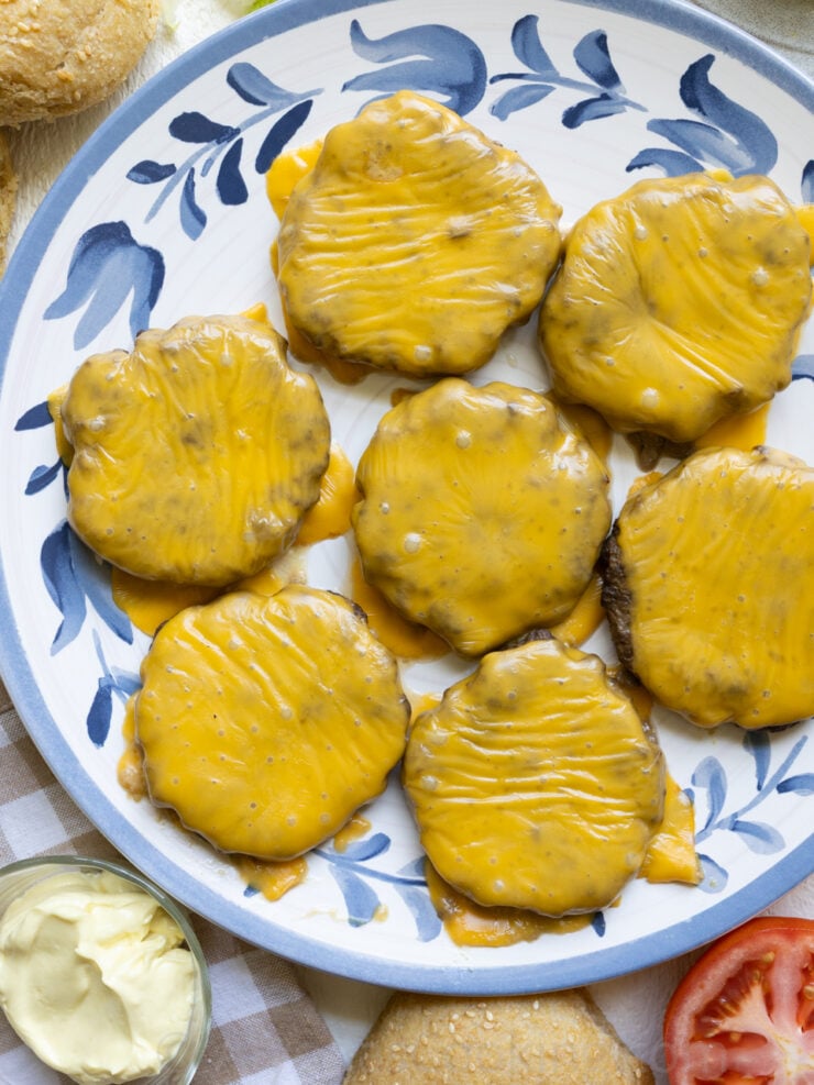 image of oven baked hamburger patties with melted American cheese on a large serving plate.