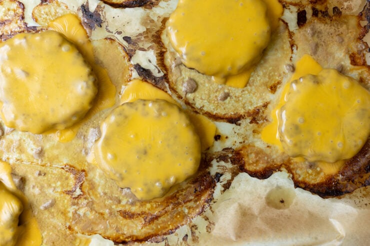 image of oven baked burgers with melted American cheese on a sheet pan (zoomed in)