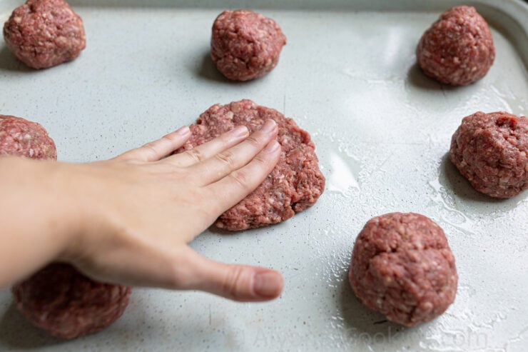 image of flattening a hamburger patty on a sheet pan