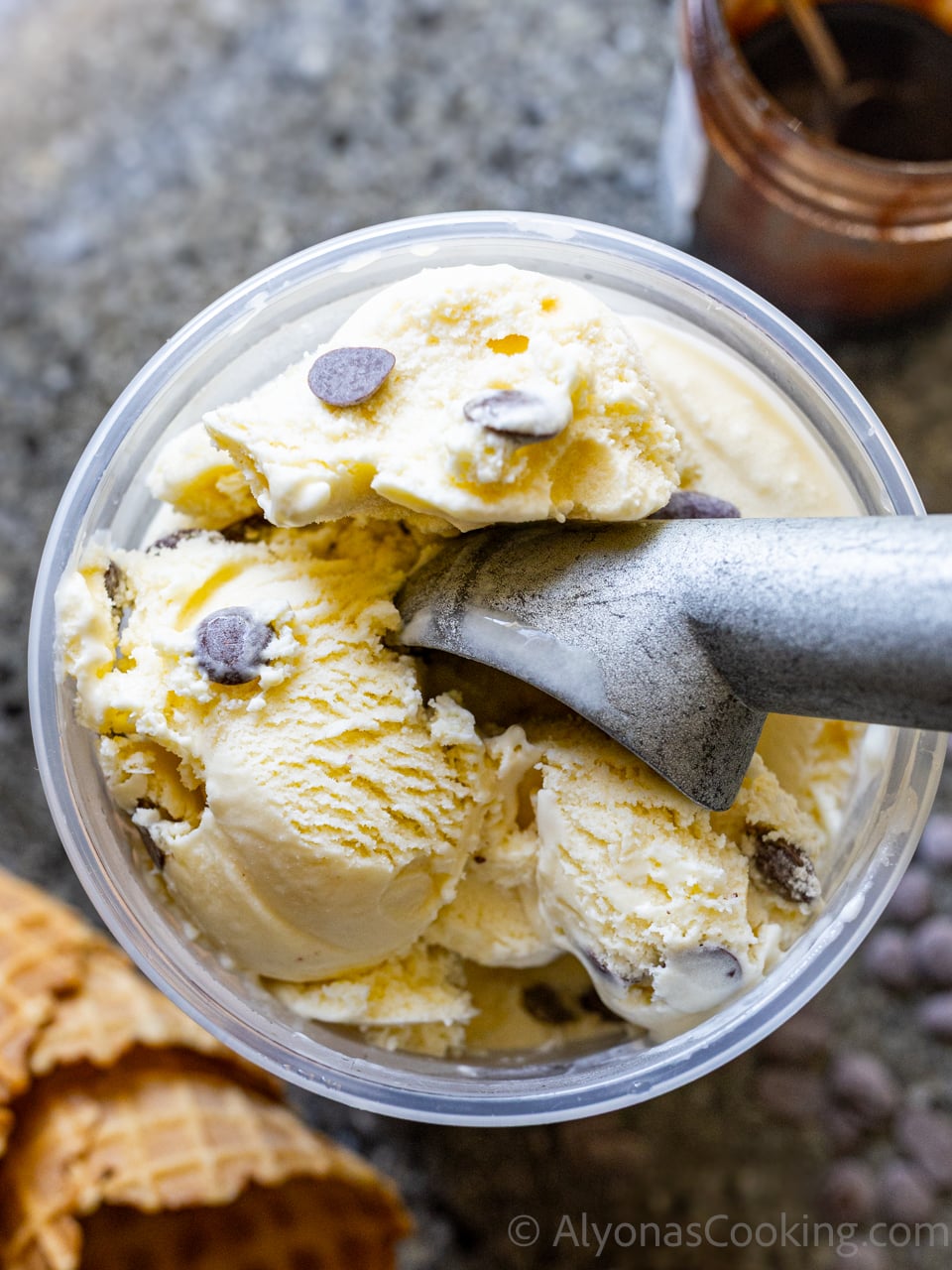 image of homemade mint chocolate chip ice cream that is not dyed scooped inside of a food container