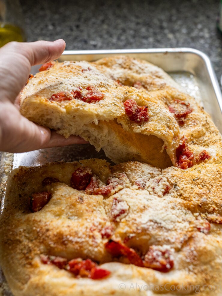 sliced homemade focaccia bread topped with parmesan and tomatoes