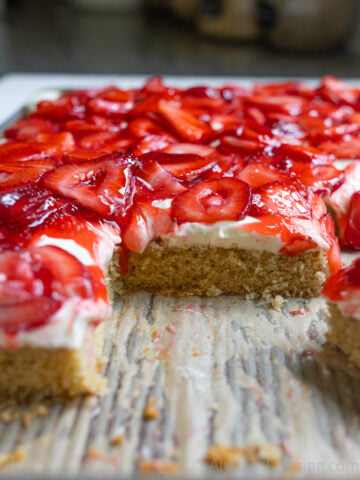 image of strawberry sheet cake sliced on a baking sheet